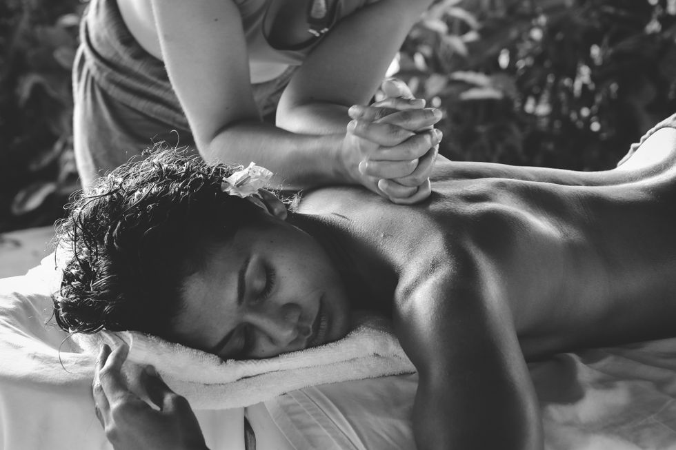 Grayscale image of a woman receiving a back massagae