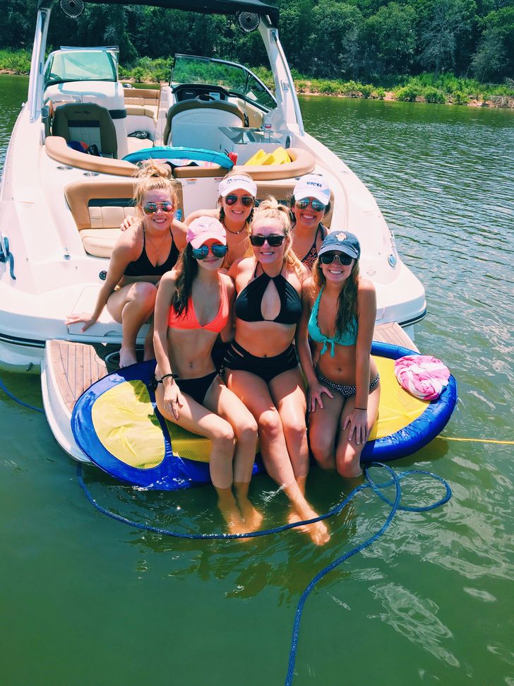Group of joyful friends sitting in a boat 