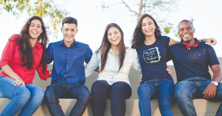group of people sitting on bench near trees during daytime
