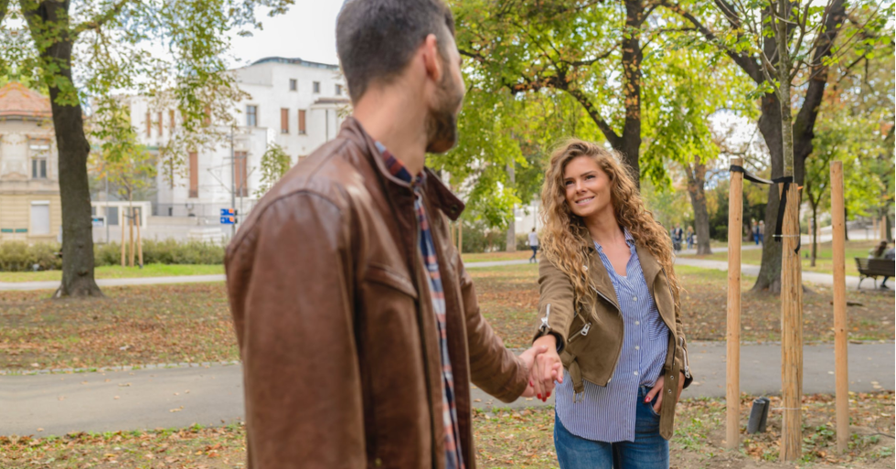 Guy and girl in brown jackets, holding hands