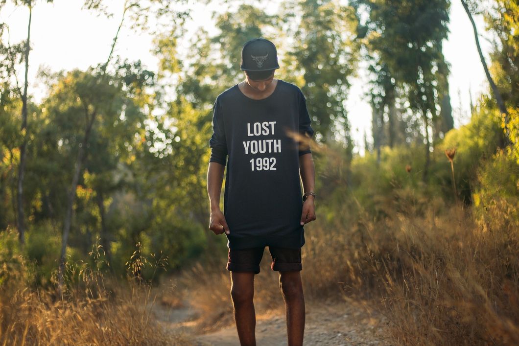 guy standing in the wild with a lost youth shirt