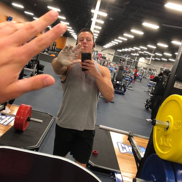 Guy taking mirror selfie in the gym