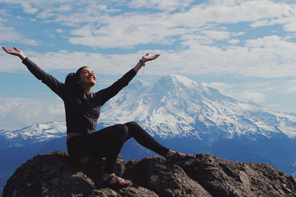 happy girl meditating on mountain