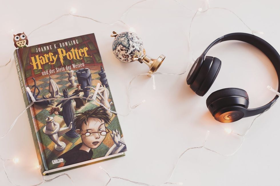 "Harry Potter" book aesthetically placed with headphones and lights 