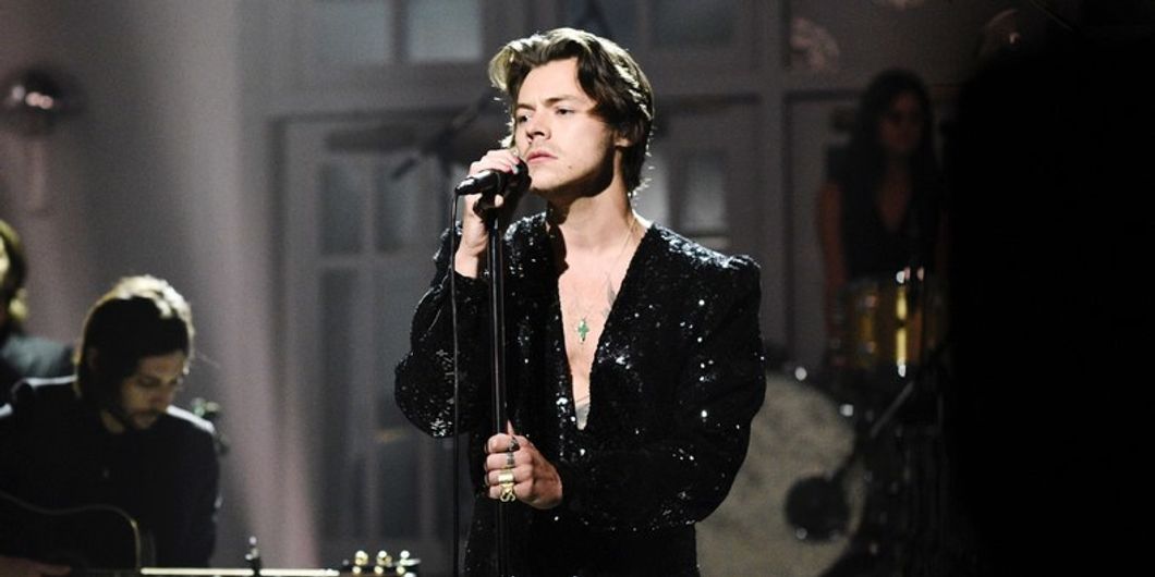 Harry Styles singing into a microphone