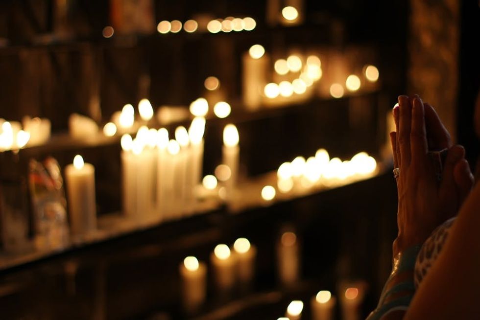 https://www.pexels.com/photo/close-up-photograph-of-person-praying-in-front-lined-candles-1024900/