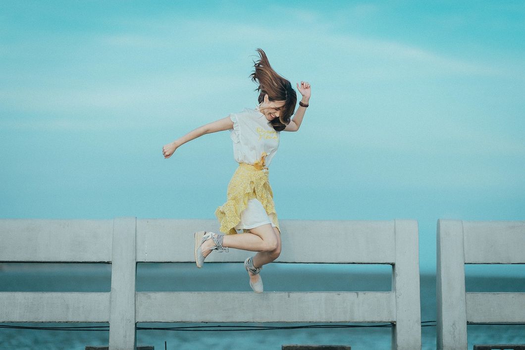 https://www.pexels.com/photo/jumpshot-photography-of-woman-in-white-and-yellow-dress-near-body-of-water-884977/