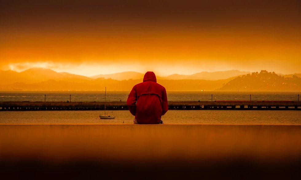 https://www.pexels.com/photo/person-wearing-red-hoodie-sitting-in-front-of-body-of-water-636164/