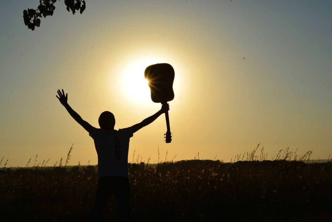 https://www.pexels.com/photo/silhouette-of-man-holding-guitar-on-plant-fields-at-daytime-89909/