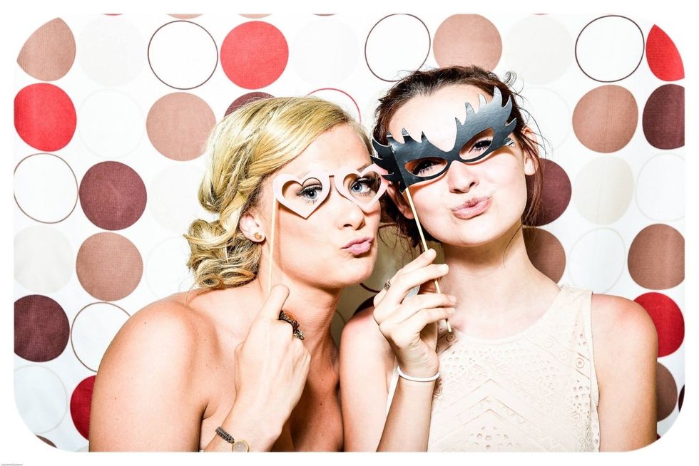 https://www.pexels.com/photo/two-woman-taking-photo-in-photobooth-holding-black-and-pink-masquerade-mask-160420/