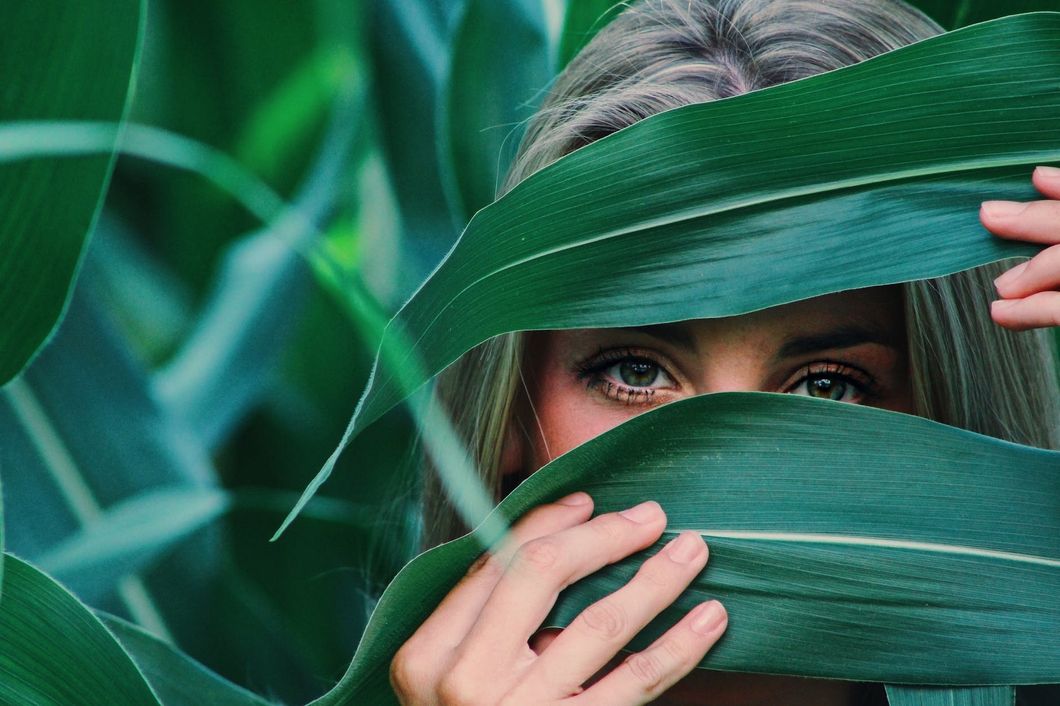 https://www.pexels.com/photo/woman-covering-her-face-with-corn-leaves-906024/
