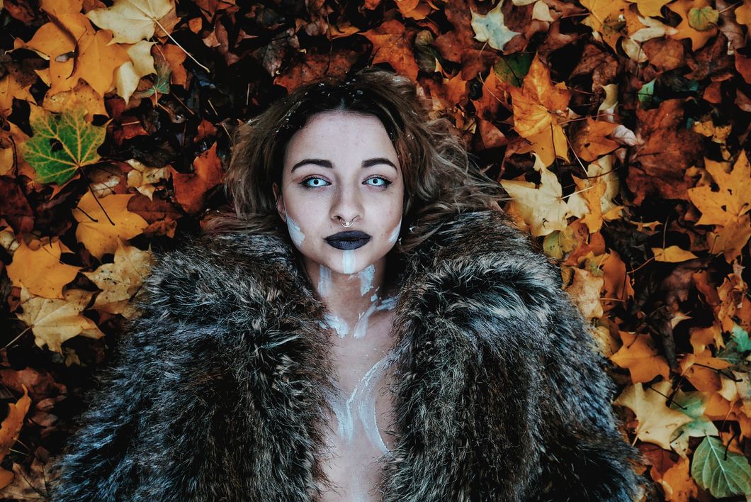 https://www.pexels.com/photo/woman-in-black-fur-coat-laying-on-brown-maple-leaves-1006197/