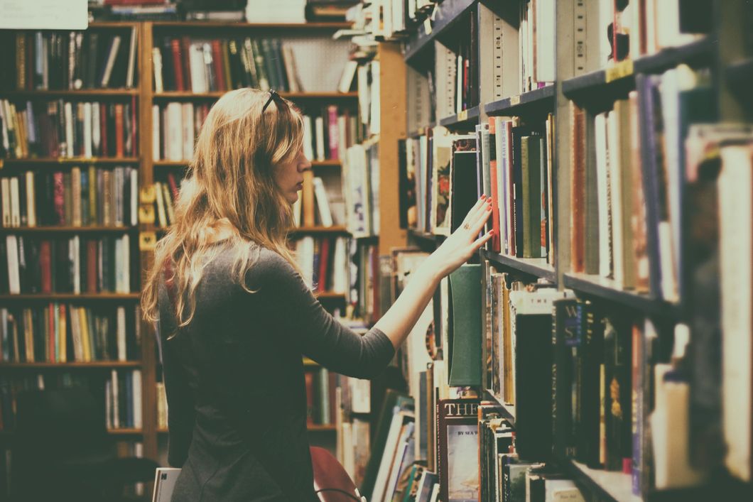 https://www.pexels.com/photo/woman-in-black-long-sleeved-looking-for-books-in-library-926680/