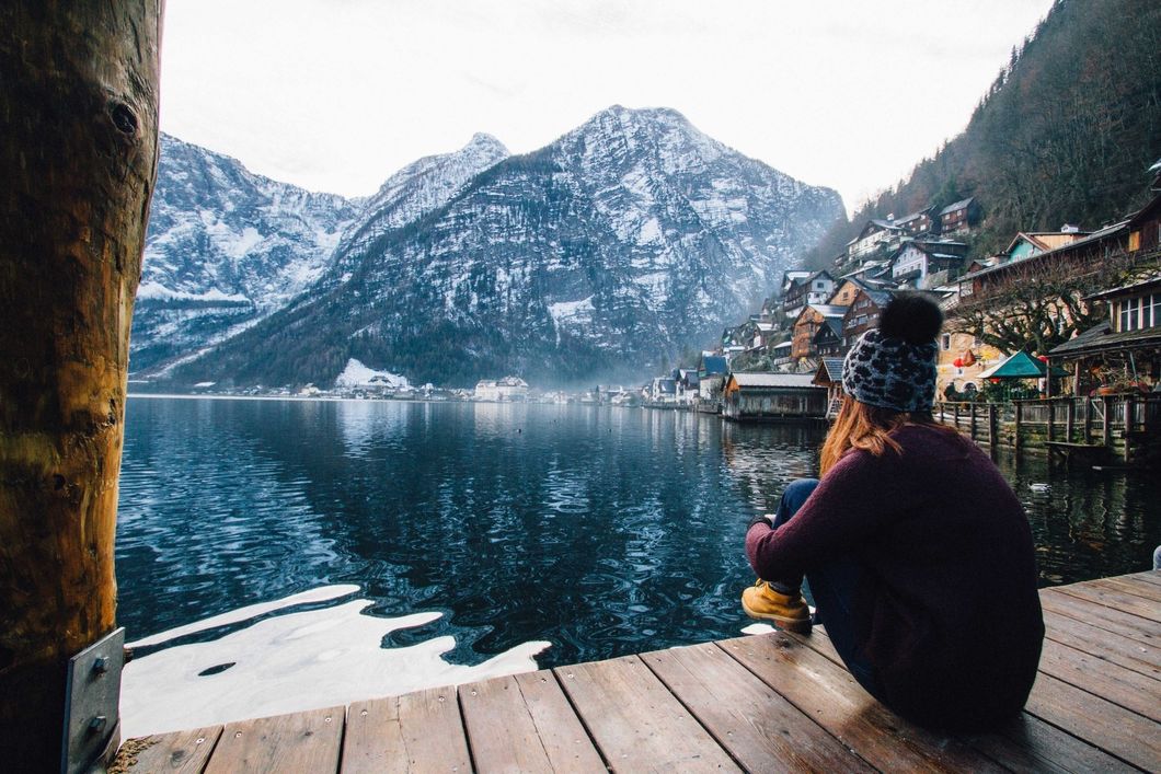 https://www.pexels.com/photo/woman-in-purple-sweater-sitting-on-wooden-floor-with-view-of-lake-and-mountains-789382/