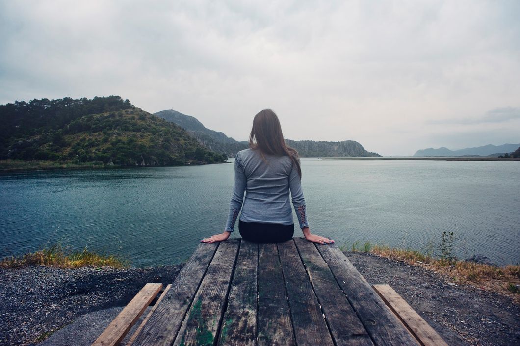 https://www.pexels.com/photo/woman-wearing-gray-long-sleeved-shirt-and-black-black-bottoms-outfit-sitting-on-gray-wooden-picnic-table-facing-towards-calm-body-of-water-at-daytime-1008000/