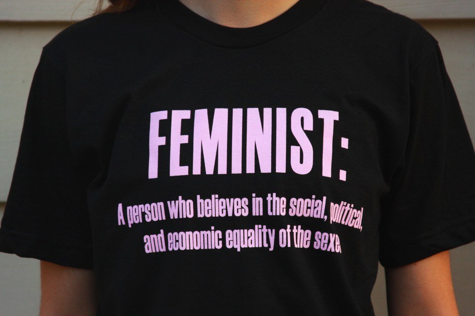 A collage of feminist merchandise, including t-shirts, mugs, and tote bags, symbolizing the commodification of feminist ideals