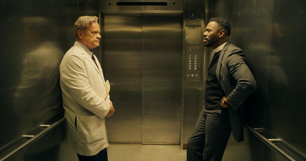 Kelsey Grammer (left) as Dr. Andre Boxer and Colman Domingo (right) as Father Dunbar face each other while waiting for their elevator to reach their destination in "The God Committee."