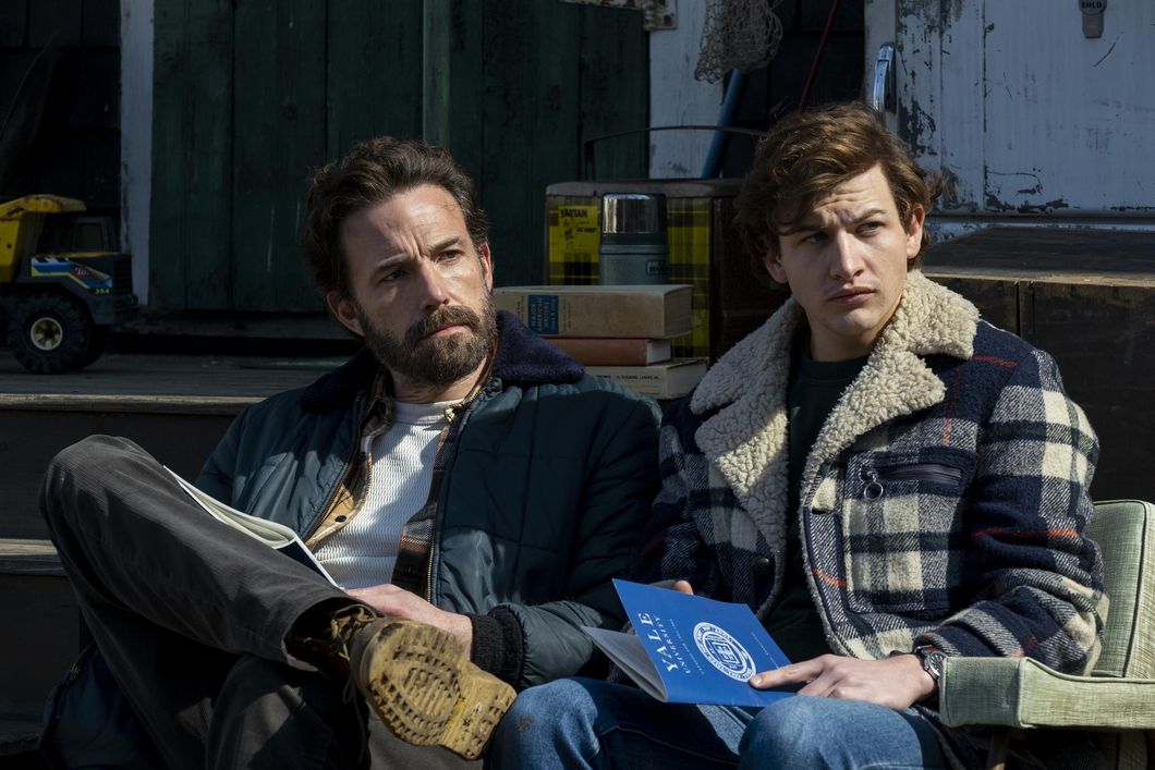 (Left to right) Ben Affleck as Uncle Charlie and Tye Sheridan as Jr sit together on a bench during a scene from Amazon Studios' "Tender Bar."\