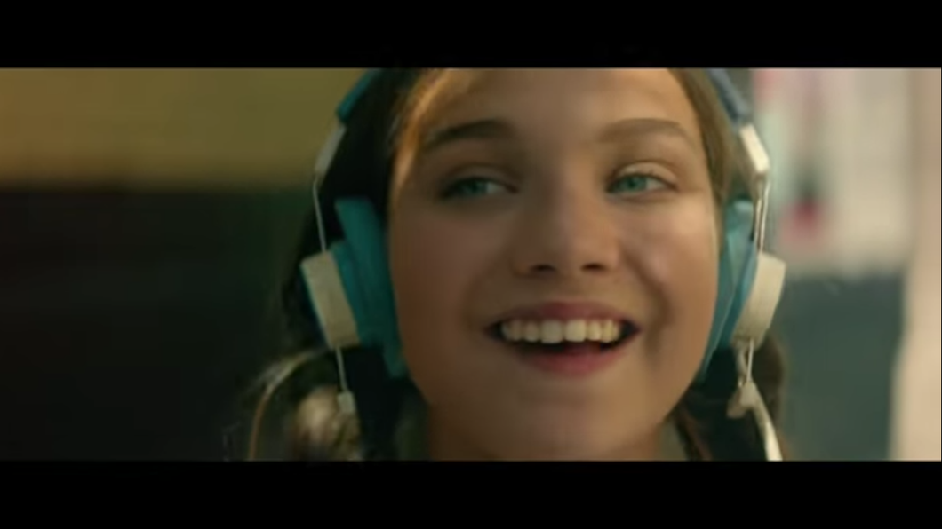 Maddie Ziegler is shown in the trailer wearing blue and white headphones