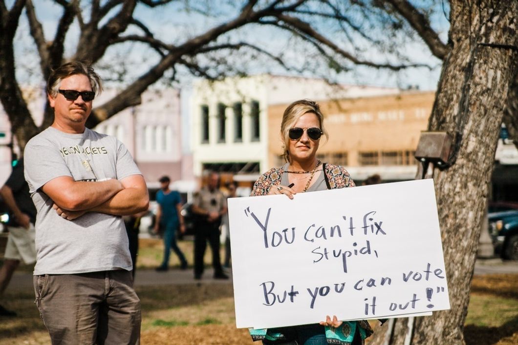 man and woman protesting holding voting sign