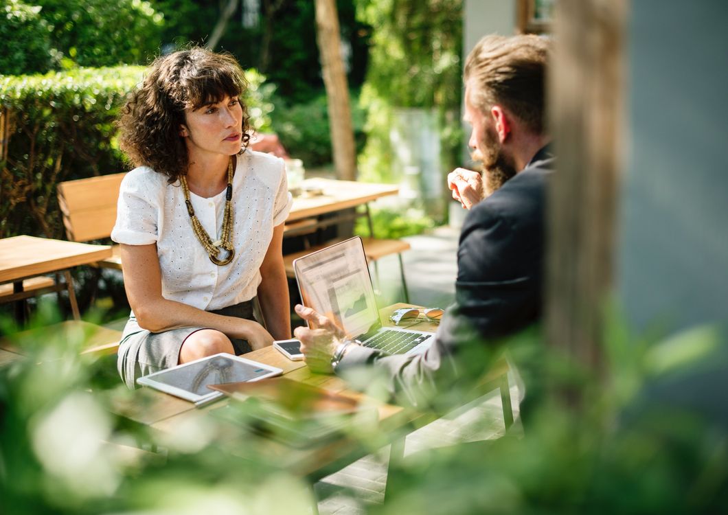 Man and woman sitting at a table and talking to each other