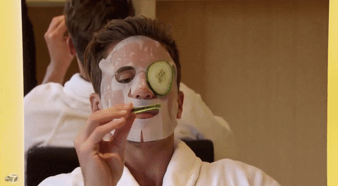 Man eating cucumber from his face mask