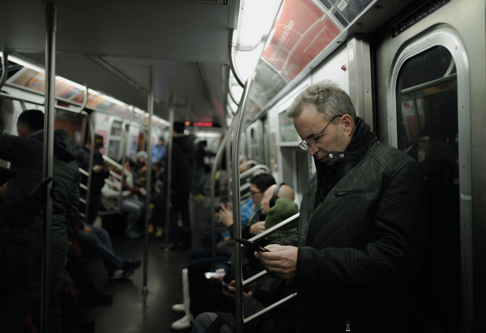 man in gray coat standing near train door