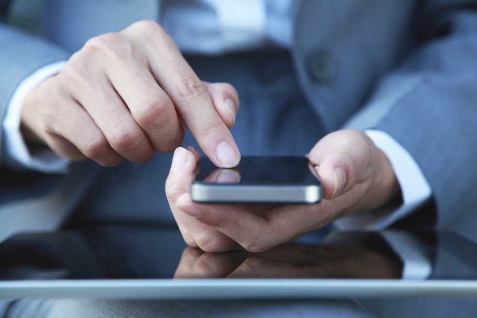 man in suit holding smart phone 