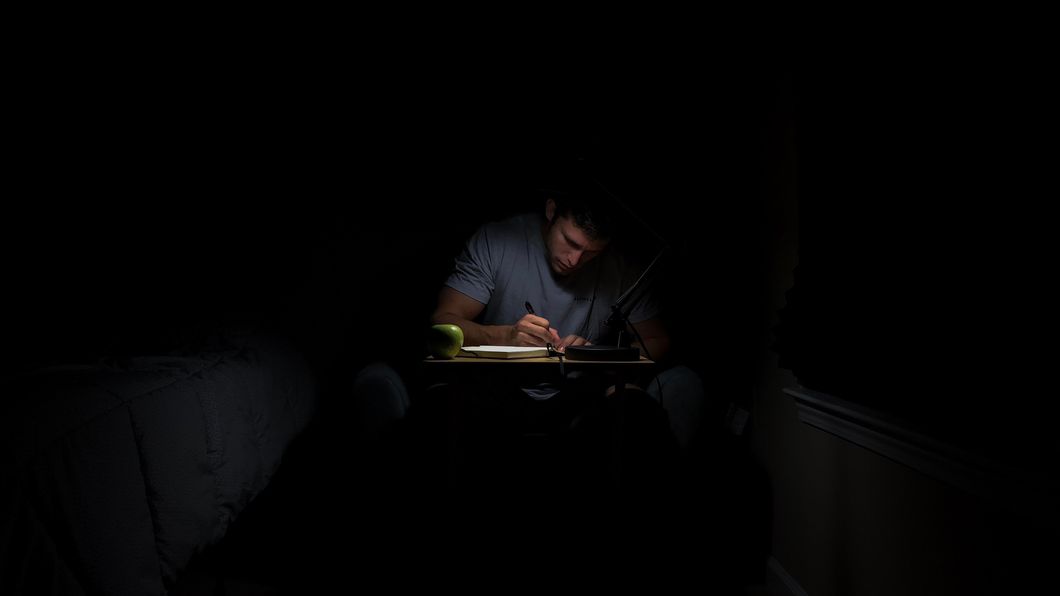 Man in the dark writing and studying