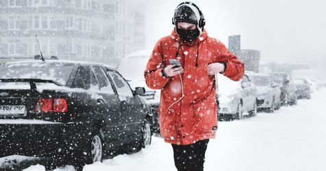 man listens to music during snowstorm