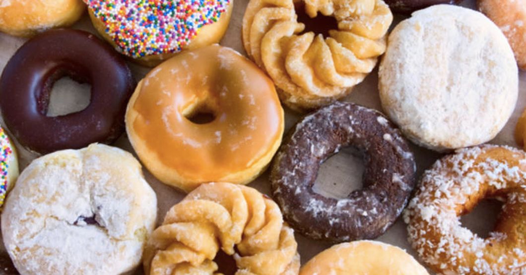 Mix of different donuts all next to eachother on a table