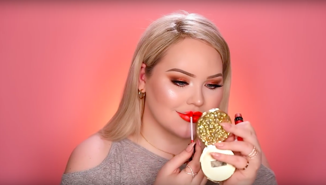 nikkietutorials putting on lipstick