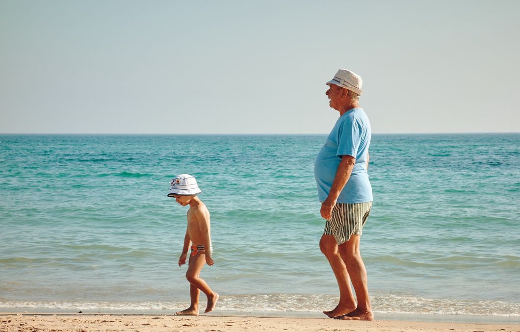Older man and child walking on the beach