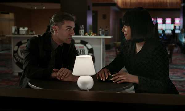 Oscar Isaac (left) as William Tell and Tiffany Haddish (right) as La Linda sit side by side in a movie still from "The Card Counter."