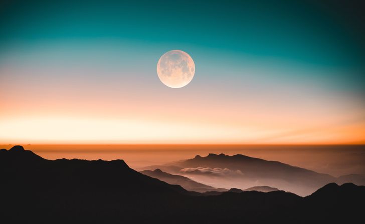 peaceful look at moon from mountain ranges, moment in time