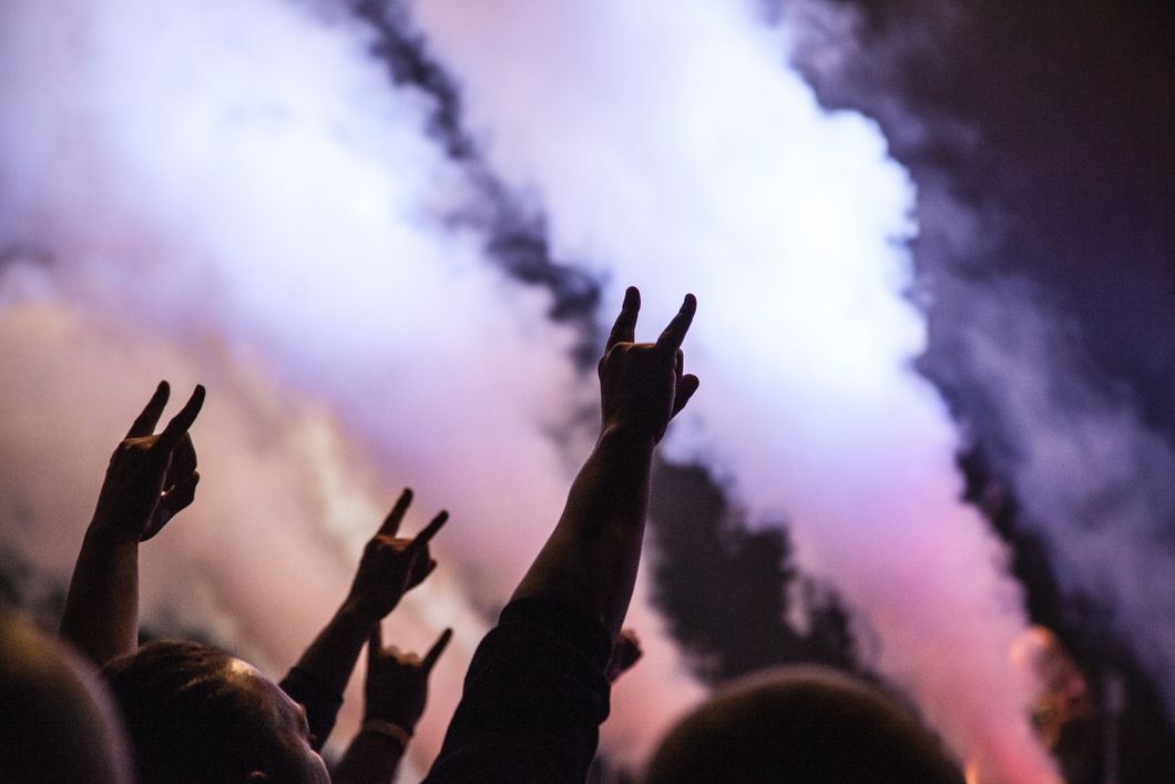 People throwing their hands into the air at a rock concert