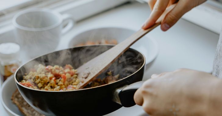 person holding black frying pan