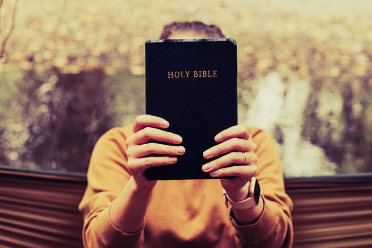 Person holding the Bible during daytime