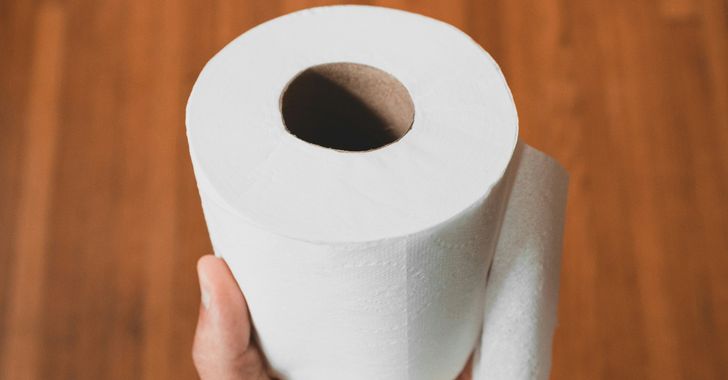 person holding white toilet paper roll