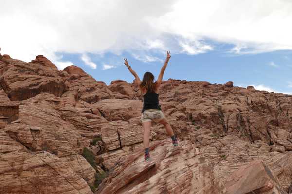 person in black tank top standing on mountain during daytime