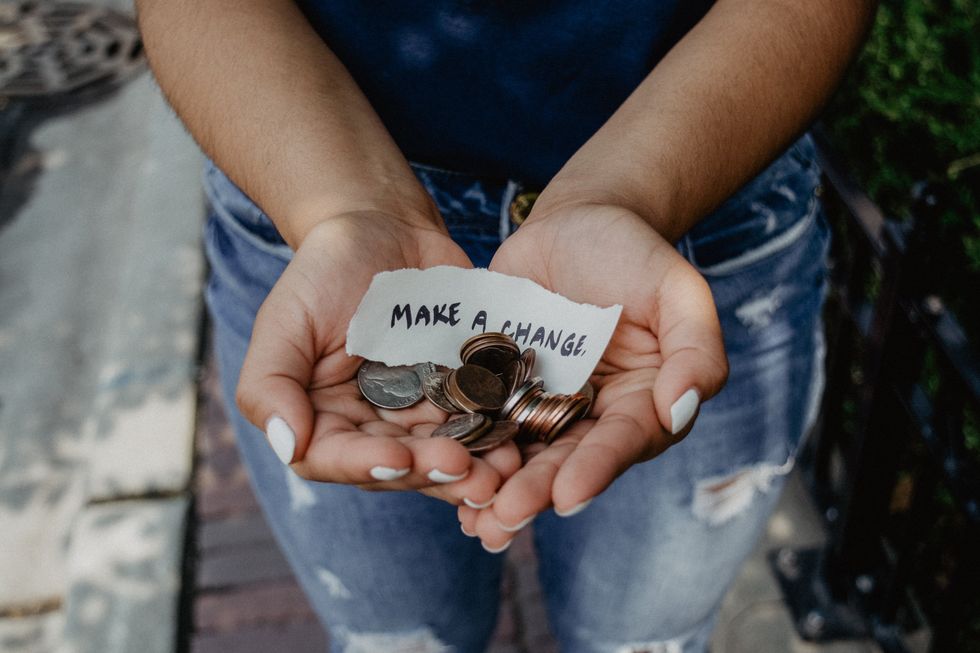 Person showing both hands with make a change note and coins