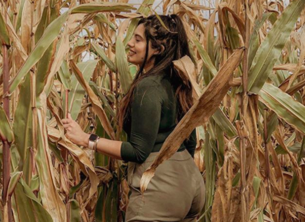 person standing in field of corn, smiling