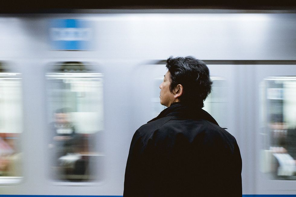 Person standing in front of a moving train.