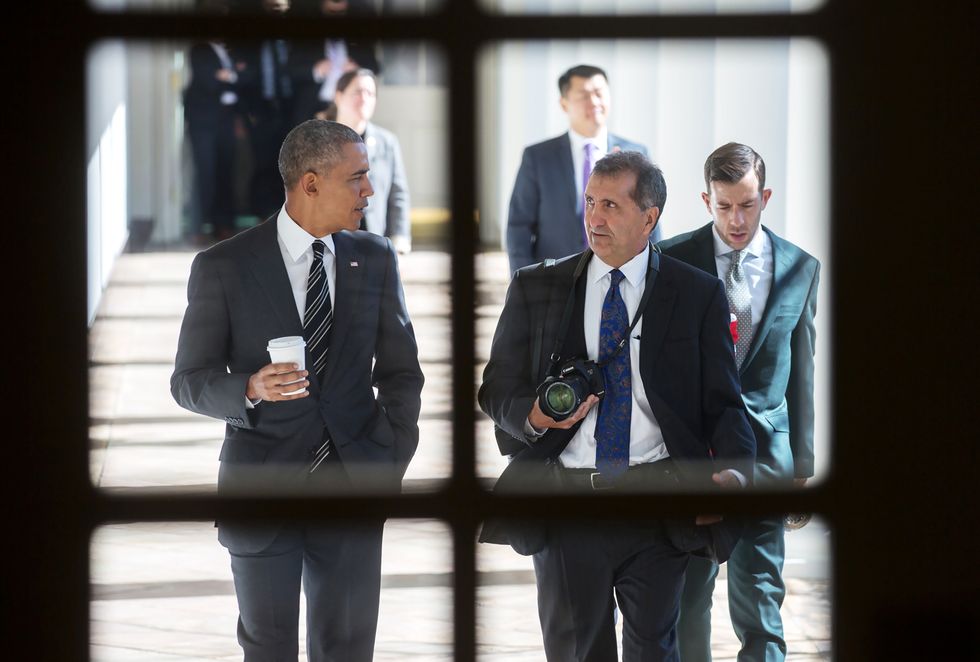​Pete Souza (right with camera) walks side-by-side with President Barack Obama in a scene from Focus Features and MSNBC Films' documentary "The Way I See It."