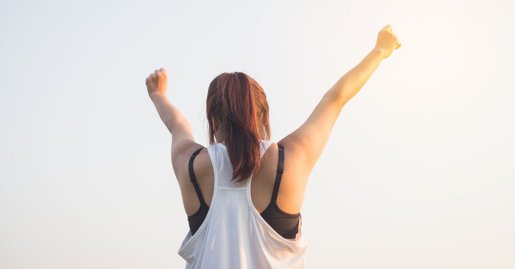 Pexels- A woman stretching her arms toward the sky.