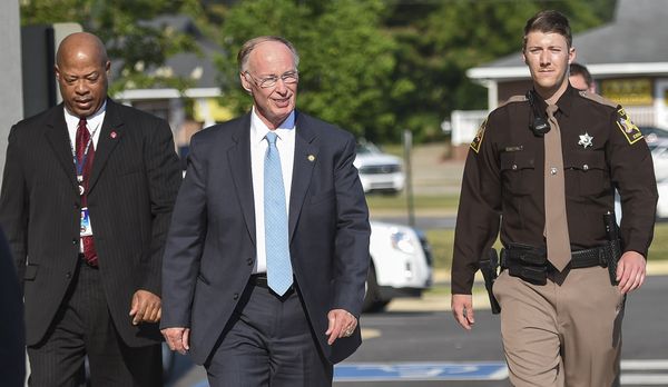 Politician is escorted by security amidst 2000s political scandals