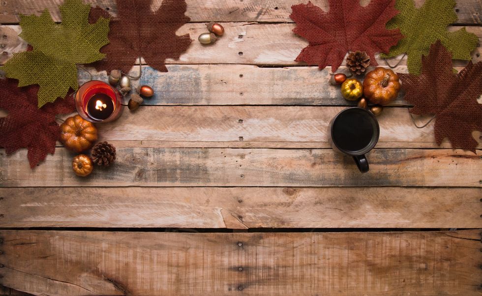 Pumpkins, leaves, candle, tea, autumn on table wooden