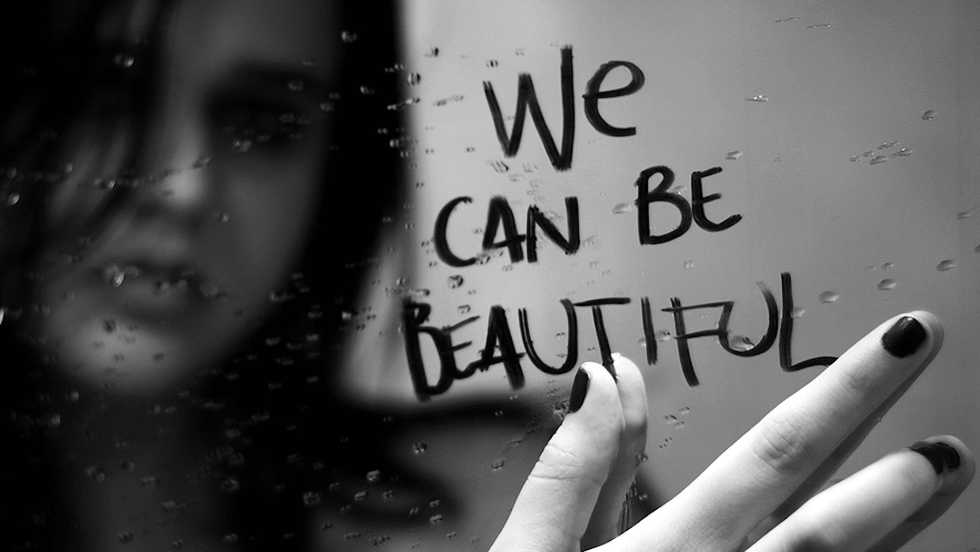 sad beautiful woman looking in mirror