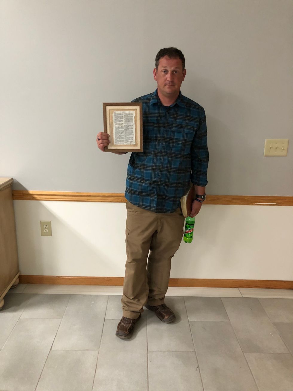 Shane with Psalm 91 that fell during April 27, 2011 tornadoes in a frame.