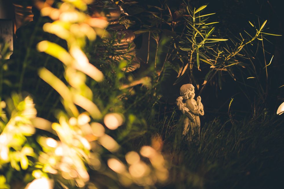 Small angel statue in grass.